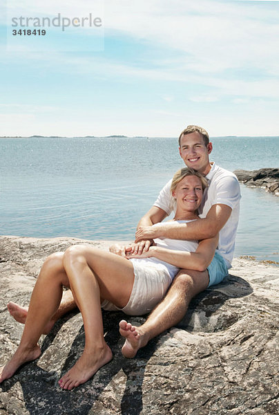 Süßes Paar am Strand sitzend