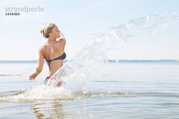 Frau spielt im Wasser