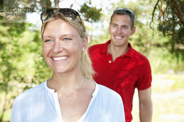 Frau und Mann  die im Wald spazieren gehen.