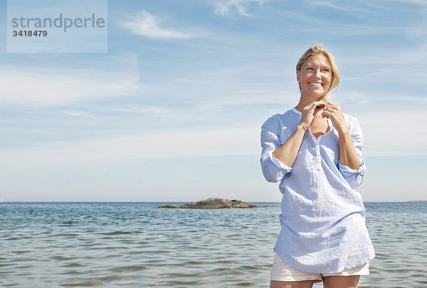 Frau am Wasser stehend