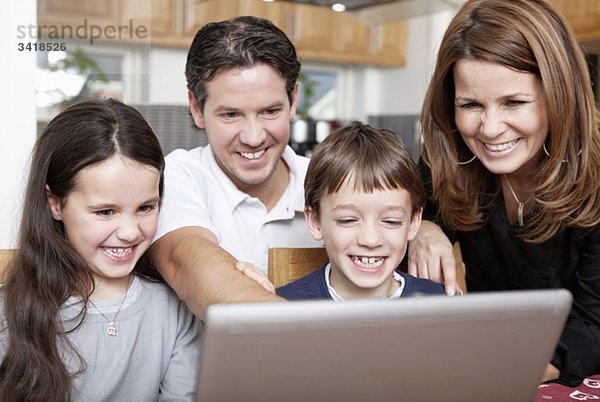 Glückliche Familie vor dem Computer