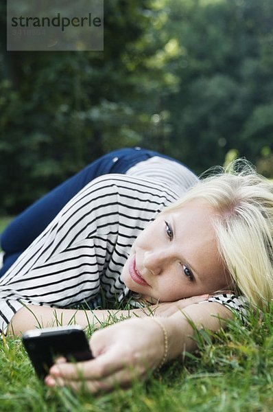 Mädchen im Park mit Telefon