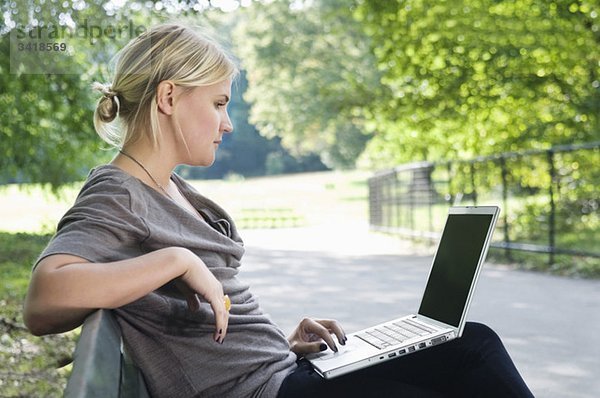 Mädchen im Park mit Computer