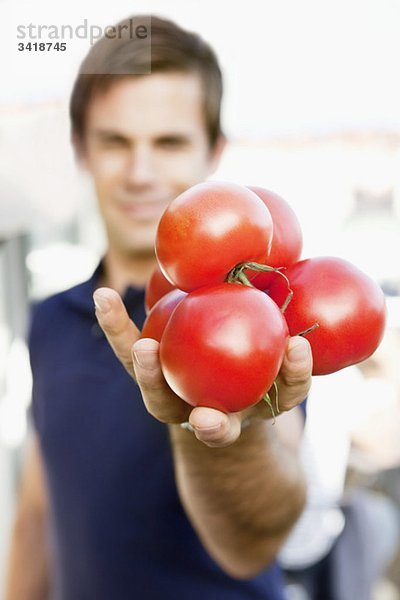 Mann  der Tomaten ausstreckt