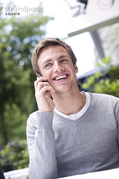 Junger Mann telefoniert mit einem Handy  Flachwinkelansicht