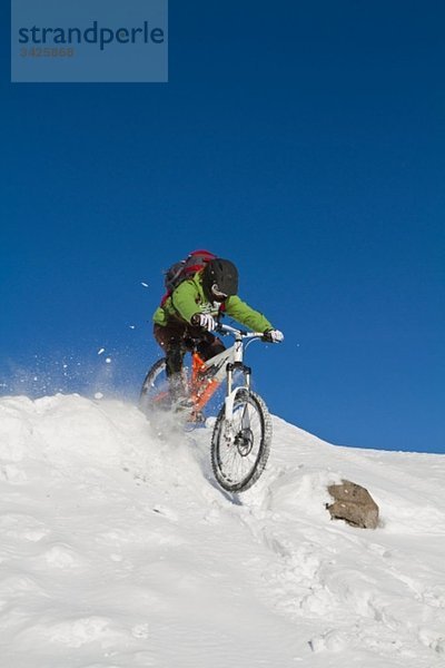 Mann Mountainbiking auf Schnee