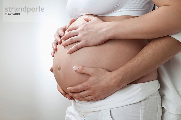 Schwangerschaftsbauch mit Paarhänden
