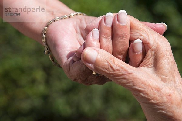 Seniorinnen halten sich an den Händen  Nahaufnahme