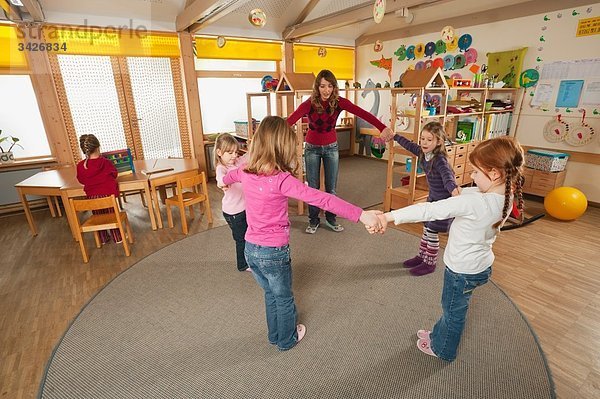 Deutschland  Kindergarten  Erzieherin und tanzende Kinder