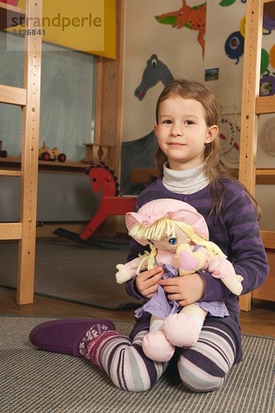 Deutschland  Portrait eines Mädchens (4-5) im Kinderzimmer mit Puppe