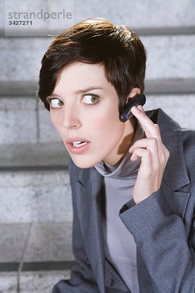 Geschäftsfrau mit Bluetooth-Headset  Portrait  Nahaufnahme