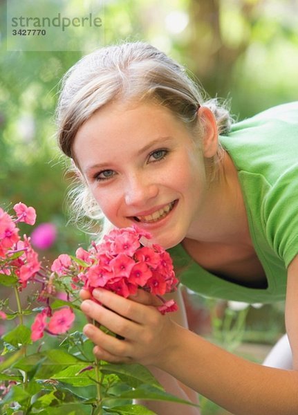 Österreich  Salzburger Land  Teenagermädchen (14-15) riechende Blumen  Portrait
