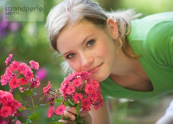 Österreich  Salzburger Land  Teenagermädchen (14-15) riechende Blumen  Portrait