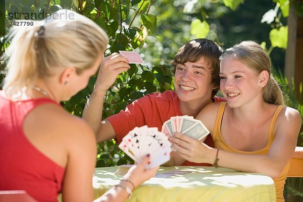 Österreich  Salzburger Land  Teenager (14-15) Spielkarten im Garten