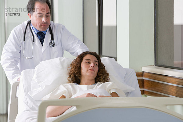 Arzt schiebt den Patienten ins Bett