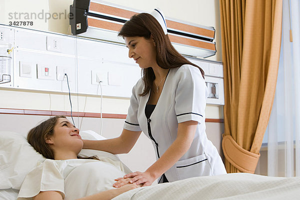 Krankenschwester  die sich um den Patienten kümmert