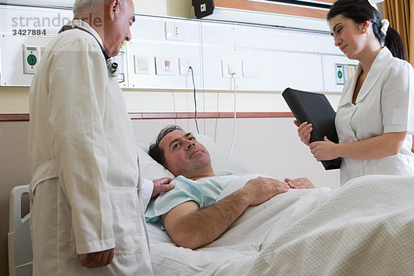 Patient im Krankenhaus mit Arzt und Krankenschwester