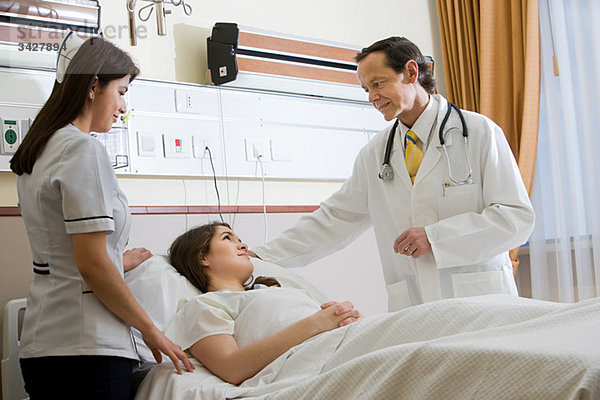 Frau im Krankenhaus mit Arzt und Krankenschwester