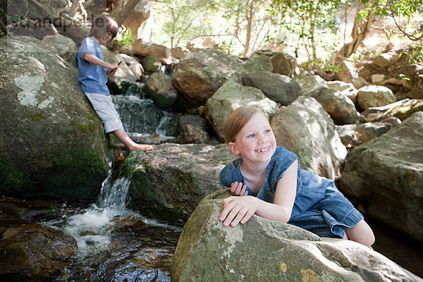 Kinder auf Felsen von river