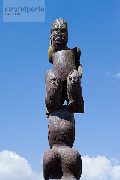 Rotorua  Holzskulptur der Maori gegen den Himmel