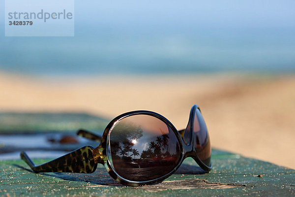 Sonnenbrille mit reflektierenden Palmen