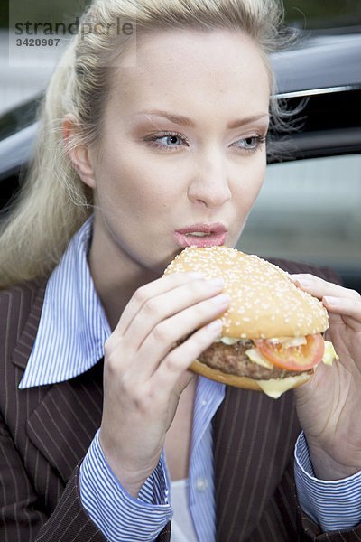 Geschäftsfrau isst einen Hamburger