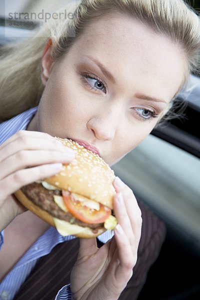 Geschäftsfrau isst einen Hamburger  Close-up