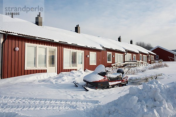 Scandinavia  Sweden  Harjedalen  Vemdalen  Snowmobile in front of house
