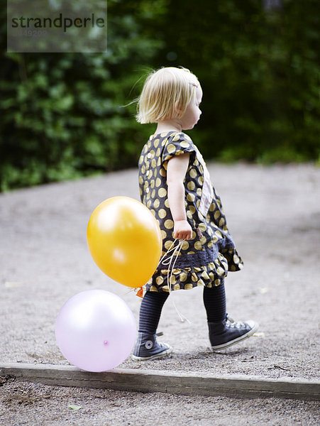 Skandinavien  Schweden  Stockholm  Mädchen zu Fuß mit der hält Ballons