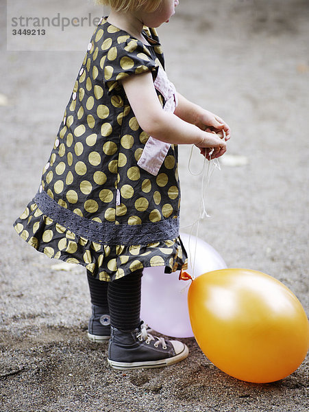 Skandinavien  Schweden  Stockholm  Girl playing with Balloons  Seitenansicht