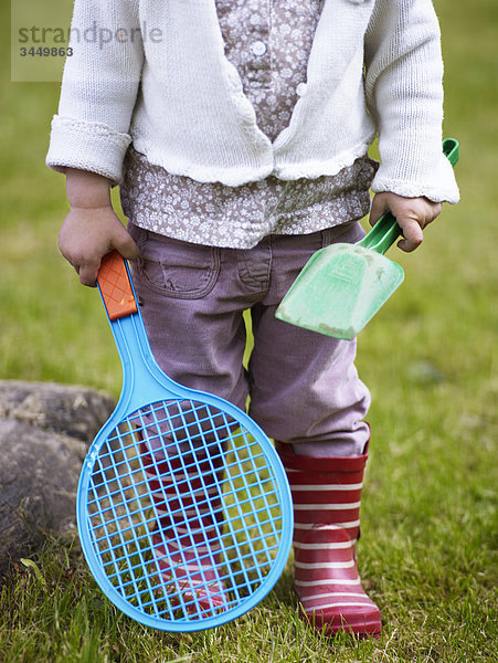 Skandinavien  Schweden  Mädchen hält Toy Spaten und Badminton  Nahaufnahme  geringer Abschnitt