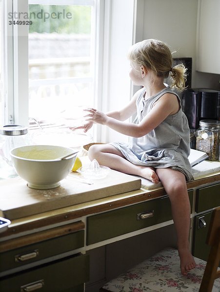 Skandinavien  Schweden  Mädchen essen in Küche zubereiten  Blick aus Fenster