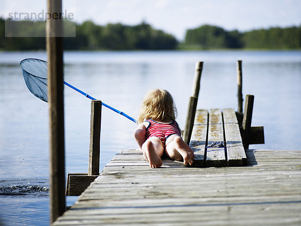 Mädchen mit Angeln net liegend auf jetty