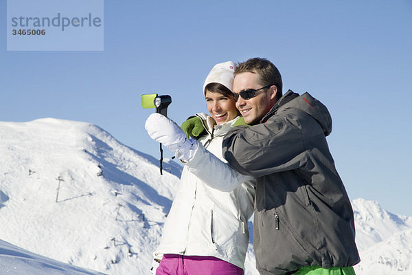 Junges Paar in Skibekleidung beim Selbstportrait