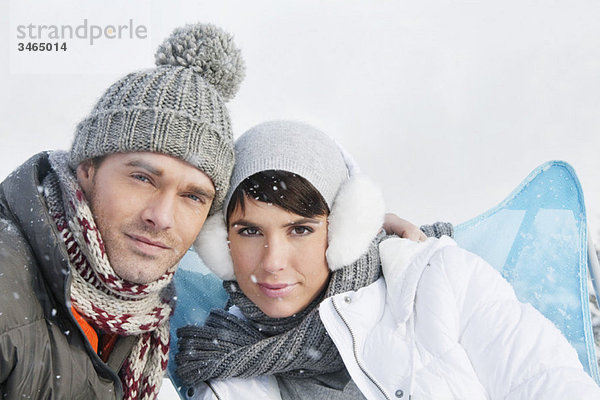 Junges Paar in Winterkleidung mit Blick auf die Kamera