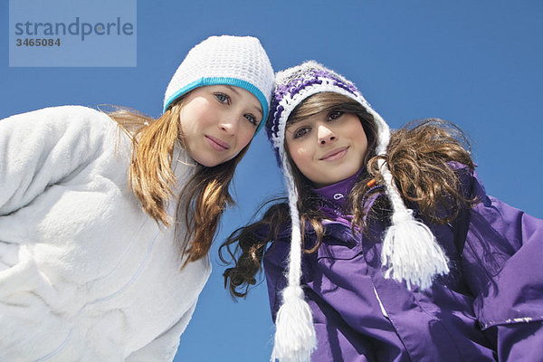 Zwei Teenagermädchen in Winterkleidung  lächelnd vor der Kamera