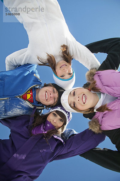 Vier Teenager in Skikleidung  lächelnd vor der Kamera