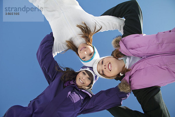 Drei Teenagermädchen in Skikleidung  lächelnd vor der Kamera