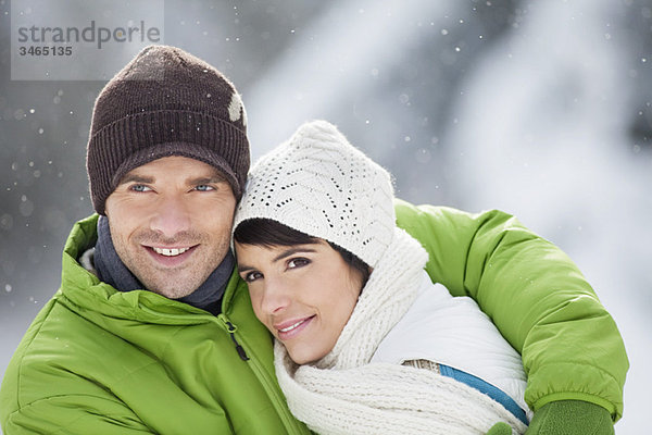 Junges Paar in Winterkleidung umarmend