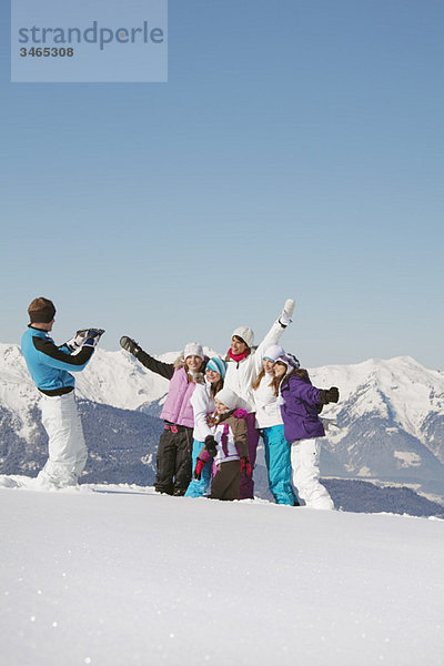 Mann fotografiert Familie im Schnee