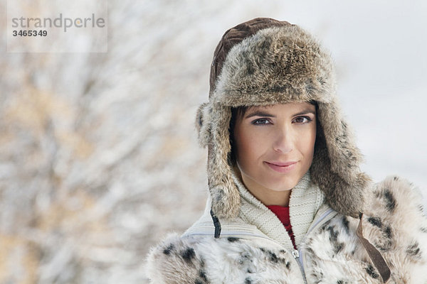 Junge Frau in Winterkleidung mit Blick auf die Kamera