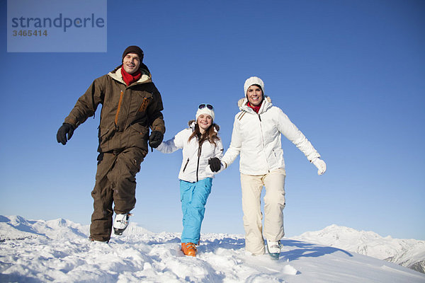 Paar und Tochter in Skibekleidung beim Wandern im Schnee