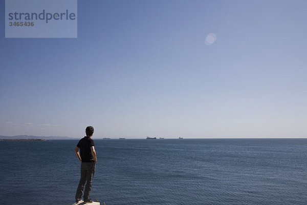 Rückansicht eines Mannes mit Blick aufs Meer  Sines  Portugal