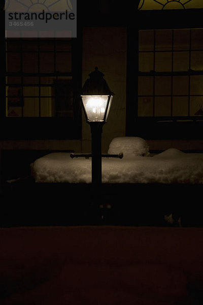 Eine beleuchtete Straßenlampe bei Nacht im Winter