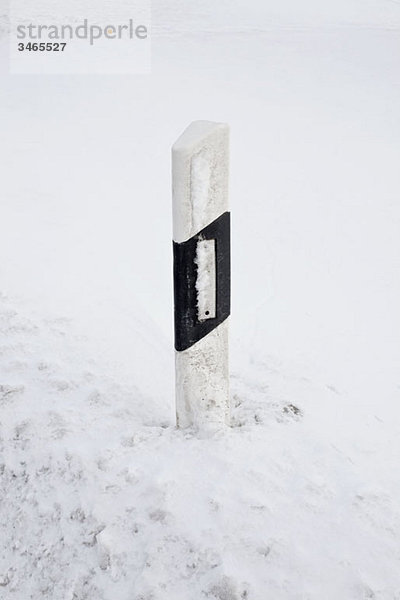 Eine Straßenmarkierung in verschneiter Umgebung