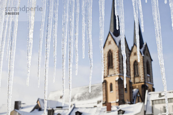 Detail von Eiszapfen und einer Kirche im Hintergrund