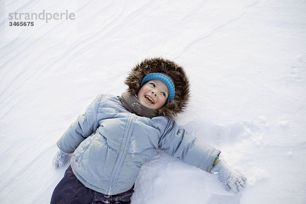 Ein Junge spielt im Schnee