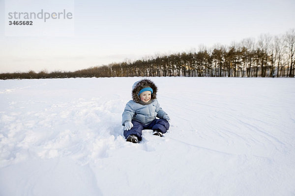 Ein Junge spielt im Schnee