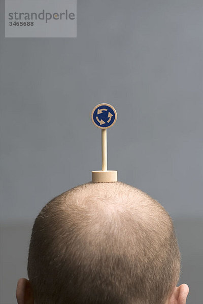 Ein Mann mit einem kleinen Kreisverkehrsschild auf dem Kopf.
