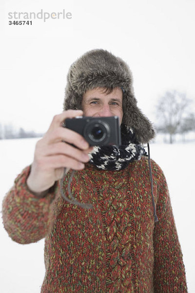 Ein Mann fotografiert mit einer Digitalkamera  im Freien  Porträt